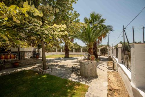 a walkway with palm trees and a fence at Palm Tree 1 in Karianí