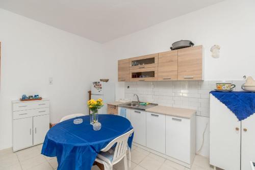 a kitchen with a table with a vase of flowers on it at Palm Tree 1 in Karianí