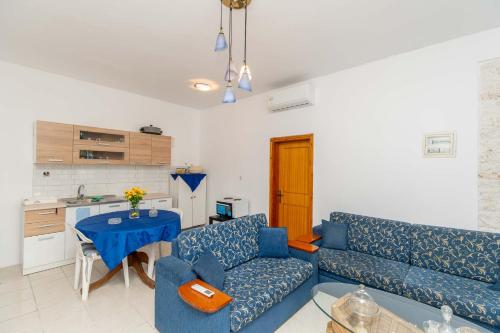 a living room with a blue couch and a table at Palm Tree 1 in Karianí