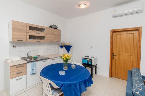 a kitchen with a table with a vase of flowers on it at Palm Tree 1 in Karianí