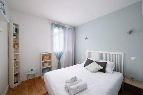 une chambre avec un lit blanc avec des serviettes dessus dans l'établissement Appartement cosy 6 pers près du lac avec garage, à Annecy