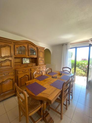 une salle à manger avec une table et des chaises en bois dans l'établissement Maison 6 personnes au calme 6MERL10, à Canet