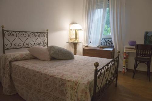 a bedroom with a bed and a chair and a window at Fior di Loto in Ravenna