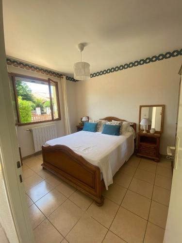 une chambre avec un grand lit et un miroir dans l'établissement Maison 6 personnes au calme 6MERL10, à Canet