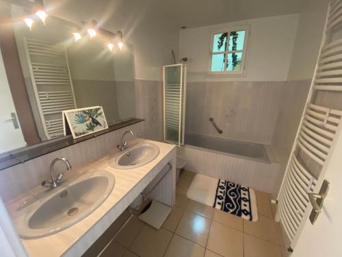 une salle de bain avec deux lavabos et un miroir dans l'établissement Maison 6 personnes au calme 6MERL10, à Canet