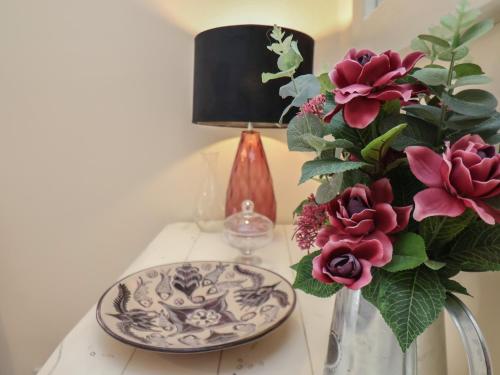 a table with a plate and a vase with flowers at North Terrace in Saltburn-by-the-Sea