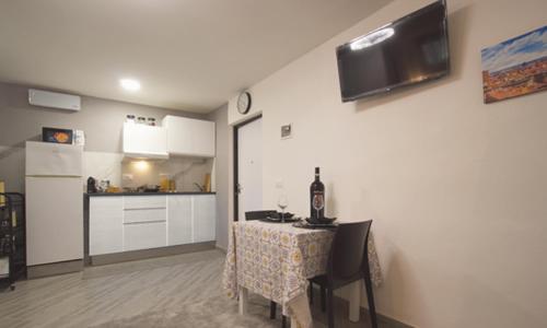 a kitchen with a table with a bottle of wine on it at Triumvirato Rooms in Bologna