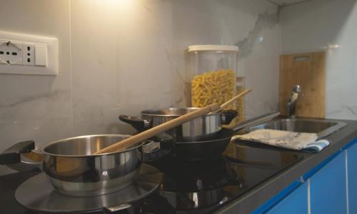 two pots and pans on a stove in a kitchen at Triumvirato Rooms in Bologna