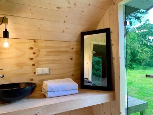 a wooden bathroom with a sink and a mirror at Twee heerlijke Boomhutten in de natuur, Amsterdam in Nigtevecht