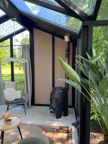 a screened in porch with a stove and a chair at Twee heerlijke Boomhutten in de natuur, Amsterdam in Nigtevecht