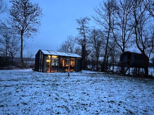 a cabin in a field with snow on the ground at Twee heerlijke Boomhutten in de natuur, Amsterdam in Nigtevecht