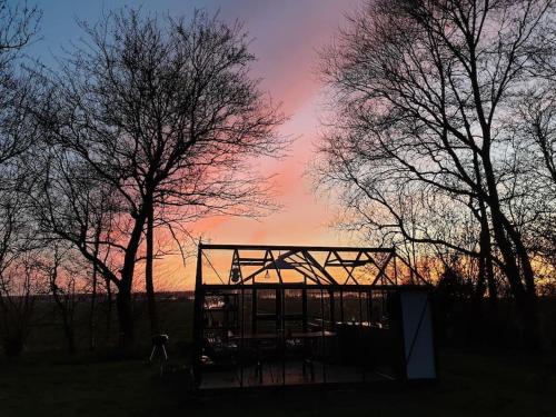a wooden structure in the middle of two trees at Twee heerlijke Boomhutten in de natuur, Amsterdam in Nigtevecht