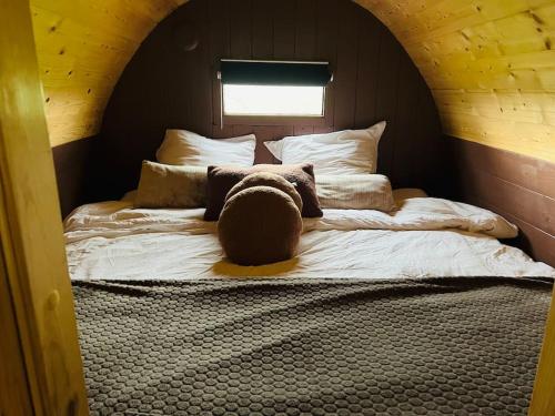 a teddy bear sitting on a bed in a room at Twee heerlijke Boomhutten in de natuur, Amsterdam in Nigtevecht
