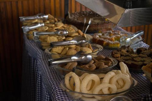 a table topped with trays of food on a table at Pousada Águas Claras in Visconde De Maua