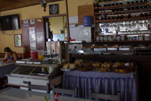 a kitchen with a counter with food on a table at Pousada Águas Claras in Visconde De Maua