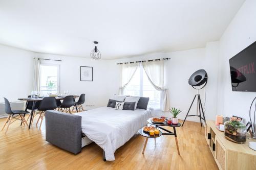une chambre avec un lit et une salle à manger dans l'établissement Cosy & Spacieux, Paris 10 min + Parking privé., à Saint-Ouen