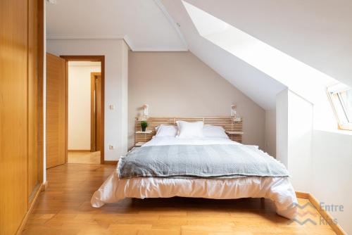 a bedroom with a large bed in a attic at Fogar do Freixo - by entreRías in Cangas de Morrazo