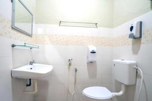 a bathroom with a toilet and a sink at De Clinique Hotel in Pangkor