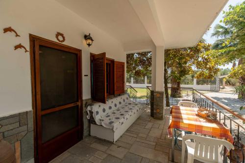 a patio with a table and chairs and a door at Palm Tree 1 in Karianí