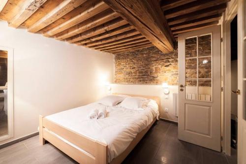 une chambre avec un grand lit blanc dans une pièce dans l'établissement La grotte de la Baleine du Vieux Lyon AIL, à Lyon