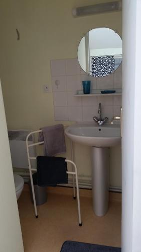 une salle de bain avec un lavabo, un miroir et une chaise dans l'établissement Le Prieure Valette, à Hérouville-Saint-Clair