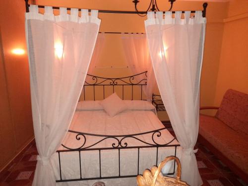 a bedroom with a bed with white curtains at El Horno de Leopoldo in Hueva