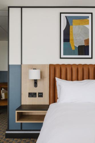 a bedroom with a bed and a table with a lamp at voco Belfast by IHG in Belfast