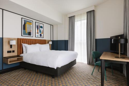 a hotel room with a bed and a desk at voco Belfast by IHG in Belfast
