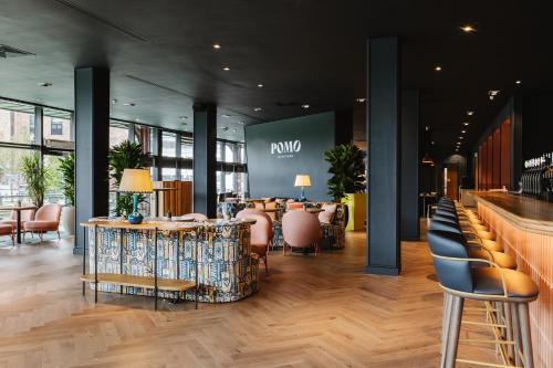 a lobby of a store with chairs and a bar at voco Belfast by IHG in Belfast