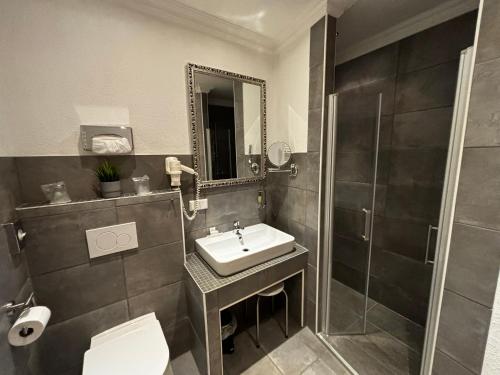 a bathroom with a sink and a toilet and a shower at Residenz Royal in Sandhausen