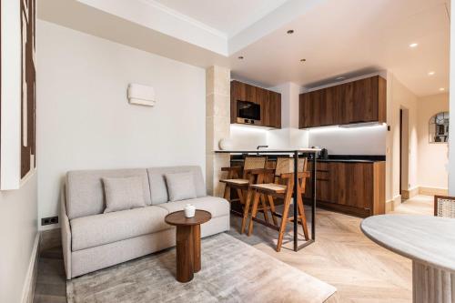 un salon avec un canapé et une table dans l'établissement Stylish Apartment - 1BR-4P - Vendôme Square, à Paris