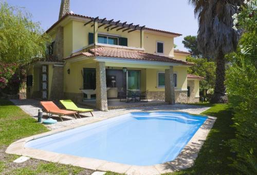 a house with a swimming pool in front of a house at Lavanda Village Cascais - Villa Jasmim I in Cascais