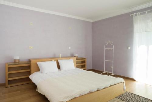 a white bedroom with a large bed with white sheets at Lavanda Village Cascais - Villa Jasmim I in Cascais