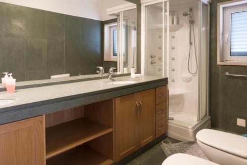 a bathroom with a sink and a shower and a toilet at Lavanda Village Cascais - Villa Jasmim I in Cascais