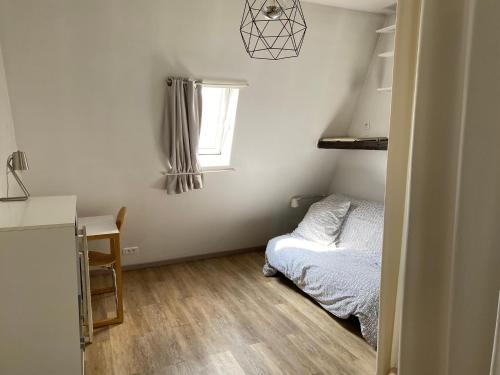 une petite chambre avec un lit et une fenêtre dans l'établissement Ruederennes, à Paris