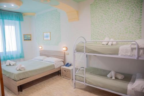 a bedroom with two bunk beds and a window at Hotel Le Tre Caravelle in Palinuro