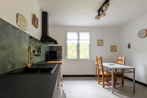- une cuisine avec un évier, une table, une table et des chaises dans l'établissement La Cigale de Provence - Maison avec vue montagne, au Cheylard