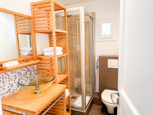 - une salle de bains avec un bol en verre sur une table en bois dans l'établissement PenBed - Concorde Champs Elysées- 3 pièces, à Paris