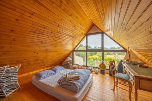 un lit dans une chambre avec un plafond en bois dans l'établissement La Renardière - Maison avec vue mer, à Barneville-Carteret