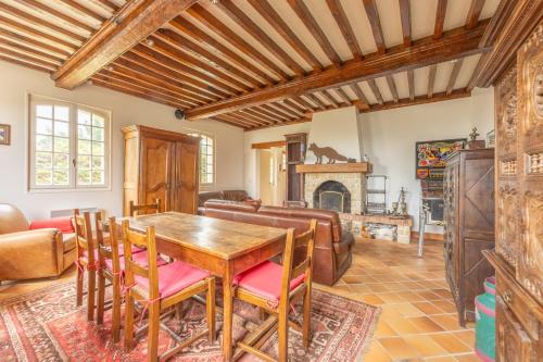 un salon avec une table et une cheminée dans l'établissement La Renardière - Maison avec vue mer, à Barneville-Carteret