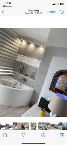 a bathroom with a white tub and a sink at Villa Theodora in front of the sea in Hanioti