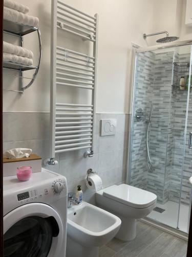 un bagno con un lavandino del water e una lavatrice di Vista Mare a 150 mt dalla spiaggia - free parking e AC a Pietra Ligure