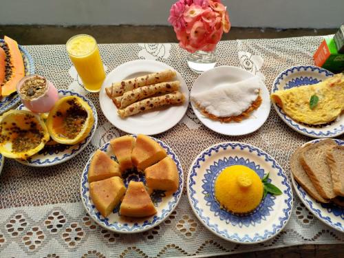 a table with blue and white plates of breakfast foods at Chill Kite - Pousada Icaraí Kite Village in Icaraí