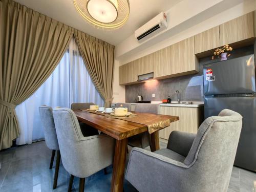 a kitchen with a wooden table and chairs and a refrigerator at Imperio Residence Melaka in Melaka