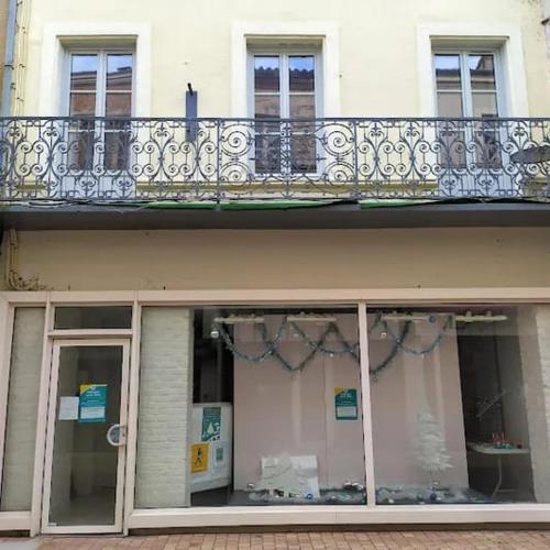 - un bâtiment avec un balcon et une fenêtre dans l'établissement Beau studio dans la Bastide, à Villeneuve-sur-Lot