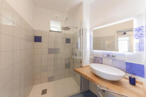 a white bathroom with a sink and a shower at Archi Suite Canneto in Canneto