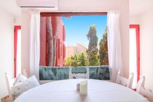 une table blanche avec une bougie devant une fenêtre dans l'établissement Apartment with communal pool Muralla Roja 0505, à Calp