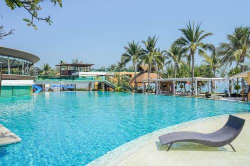 a swimming pool with a chair in a resort at Springfield @Sea Resort & Spa in Cha Am