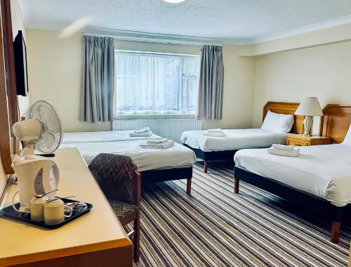 a hotel room with two beds and a window at Carrington House Hotel in Bournemouth