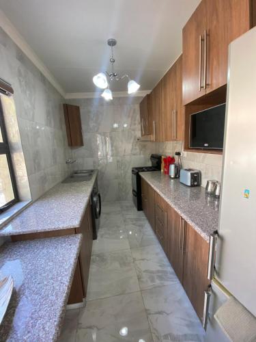 a kitchen with granite counter tops and a refrigerator at Garden Oasis Cottage in Windhoek